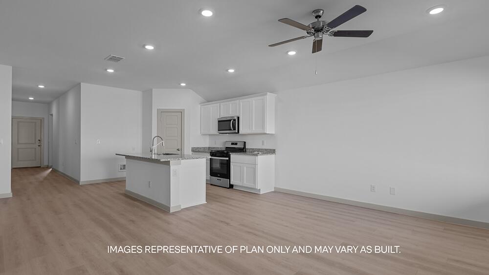 7445 9th Street Lubbock, TX 79416 - Photo 5 of 16 a view of kitchen with cabinets microwave and stove