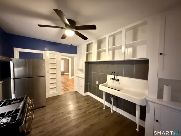 a room with furniture a ceiling fan and a window