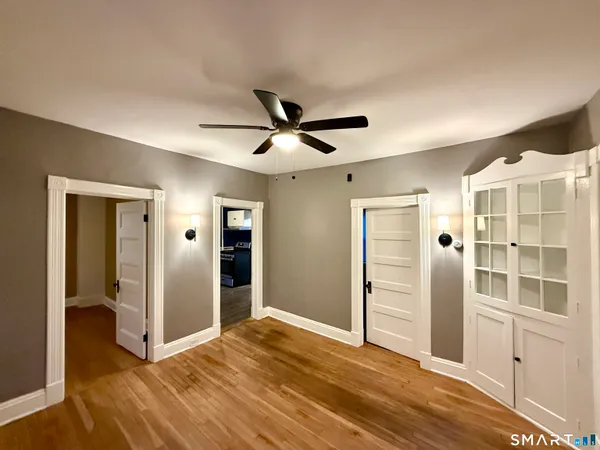 a view of an empty room with cabinet and a ceiling fan