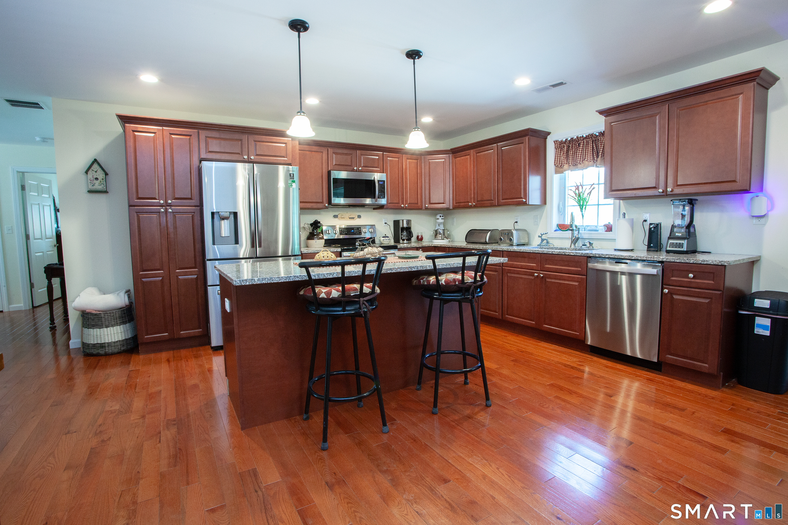 3 Hannah Way Torrington, CT 06790 - Photo 4 of 23 a open kitchen with stainless steel appliances granite countertop a stove a refrigerator a sink a dining table and chairs with wooden floor