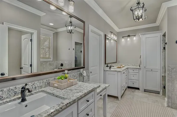 a bathroom with a granite countertop sink double vanity and a mirror