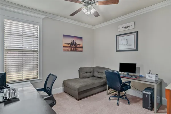 a view of a workspace with furniture and a window