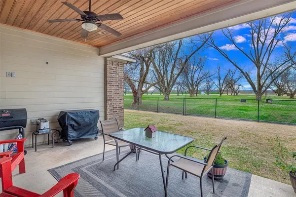 a patio with table and chairs and a barbeque