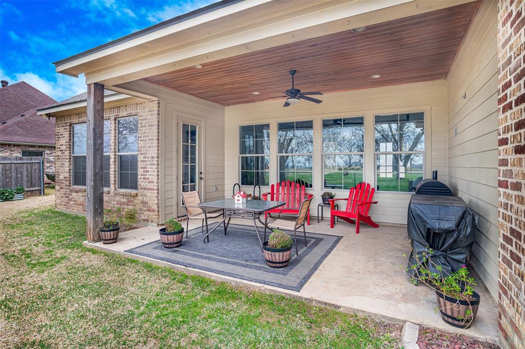 106 Pear Tree Lane Benton, LA 71006 - Photo 23 of 26 a view of a patio with table and chairs barbeque potted plants and large tree