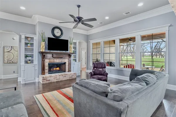 a living room with furniture a fireplace and a flat screen tv