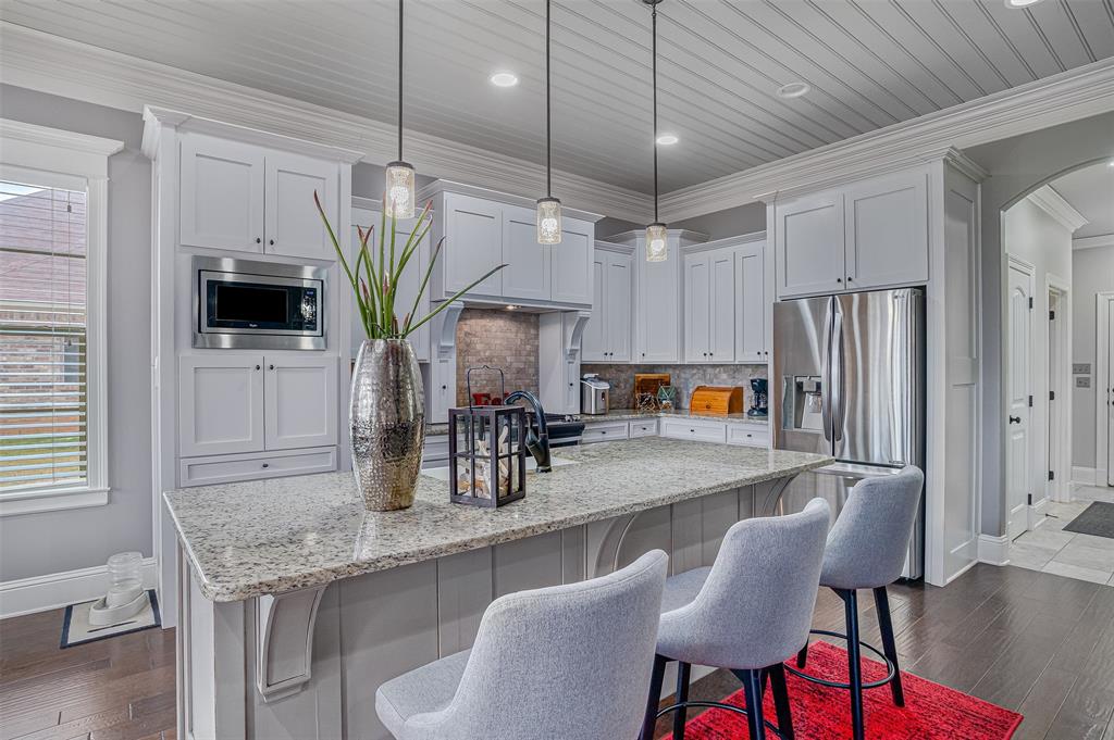 106 Pear Tree Lane Benton, LA 71006 - Photo 9 of 26 a kitchen with stainless steel appliances granite countertop a table chairs in it and wooden floors