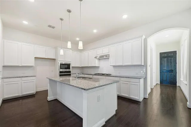 a kitchen with a stove a sink and a refrigerator