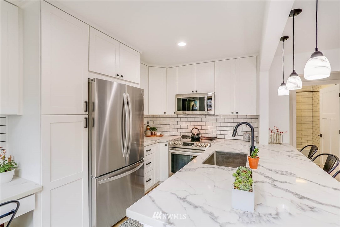 1108 North 41st Street Seattle, WA 98103 - Photo 10 of 32 a kitchen with stainless steel appliances a refrigerator sink and microwave