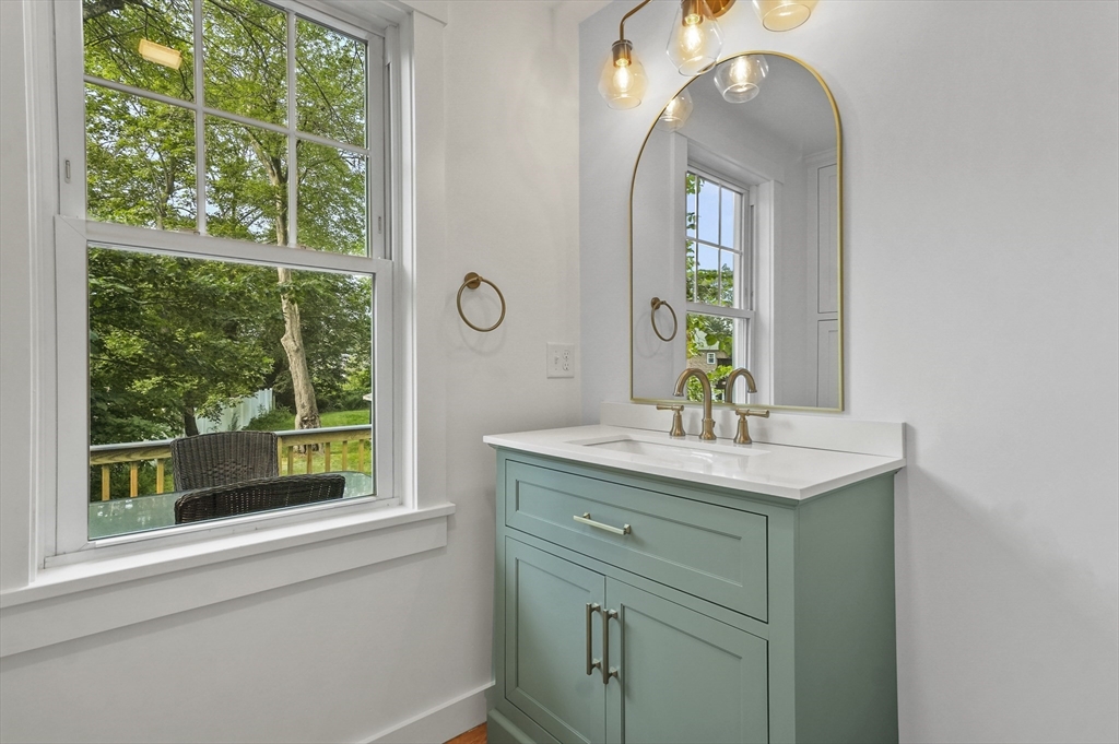 224 Elm Street Amesbury, MA 01913 - Photo 12 of 29 a bathroom with a granite countertop sink a large mirror a vanity and a window