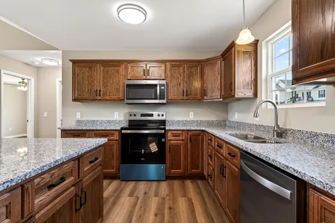 a kitchen with stainless steel appliances granite countertop a sink stove and microwave