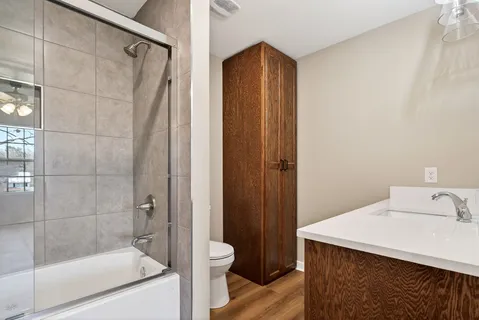 a bathroom with a shower a sink and toilet