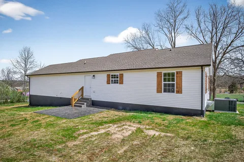 a backyard of a house with table and chairs