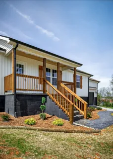 a view of house with wooden deck front of house
