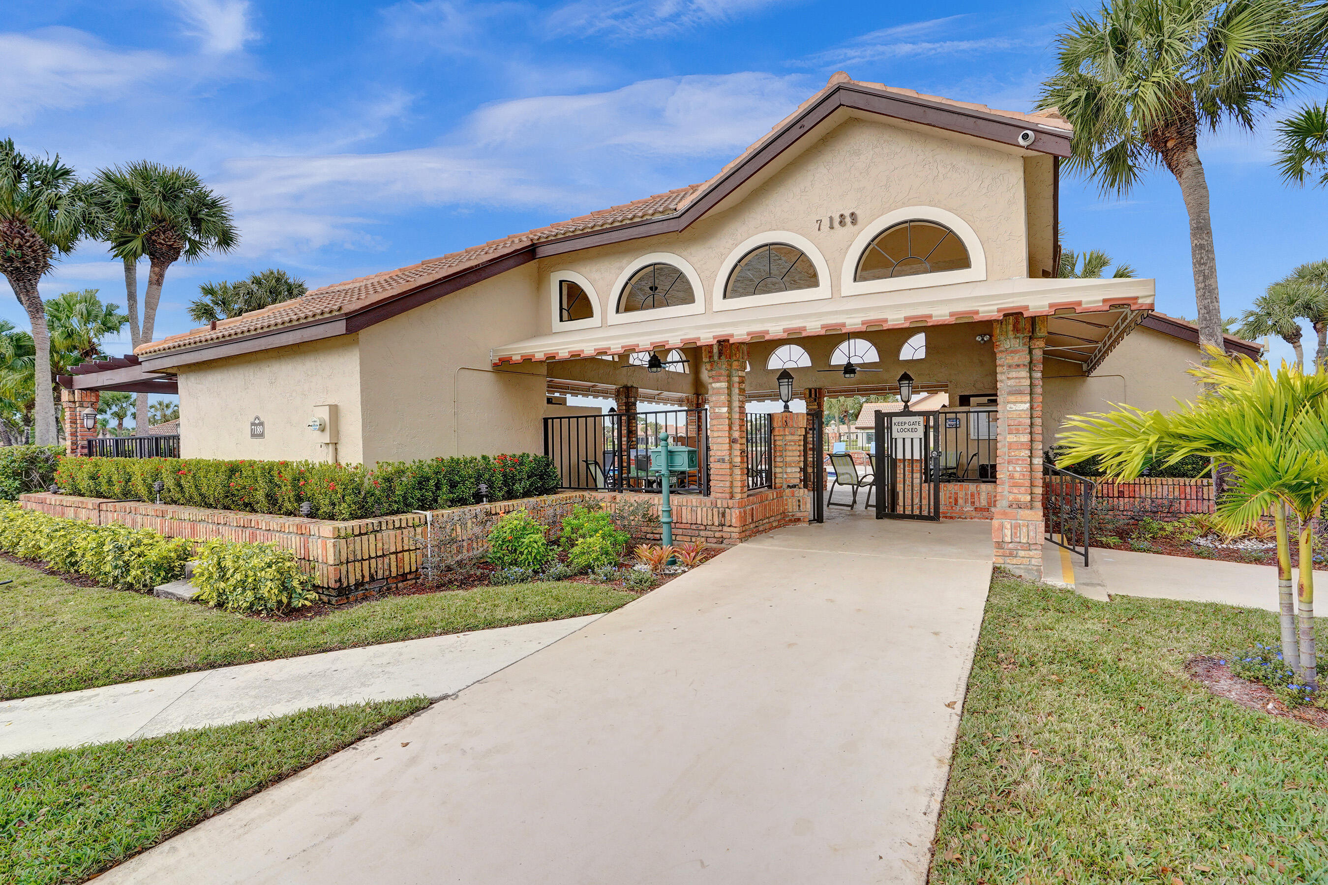8062 Cassia Drive Boynton Beach, FL 33472 - Photo 51 of 70 a view of a white house with a big yard and potted plants