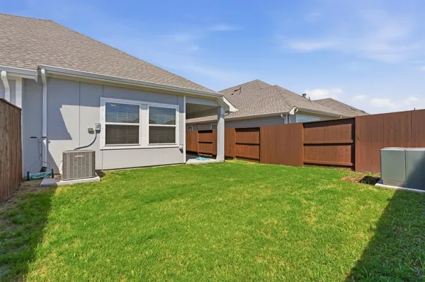 a backyard of a house with barbeque oven and wooden fence