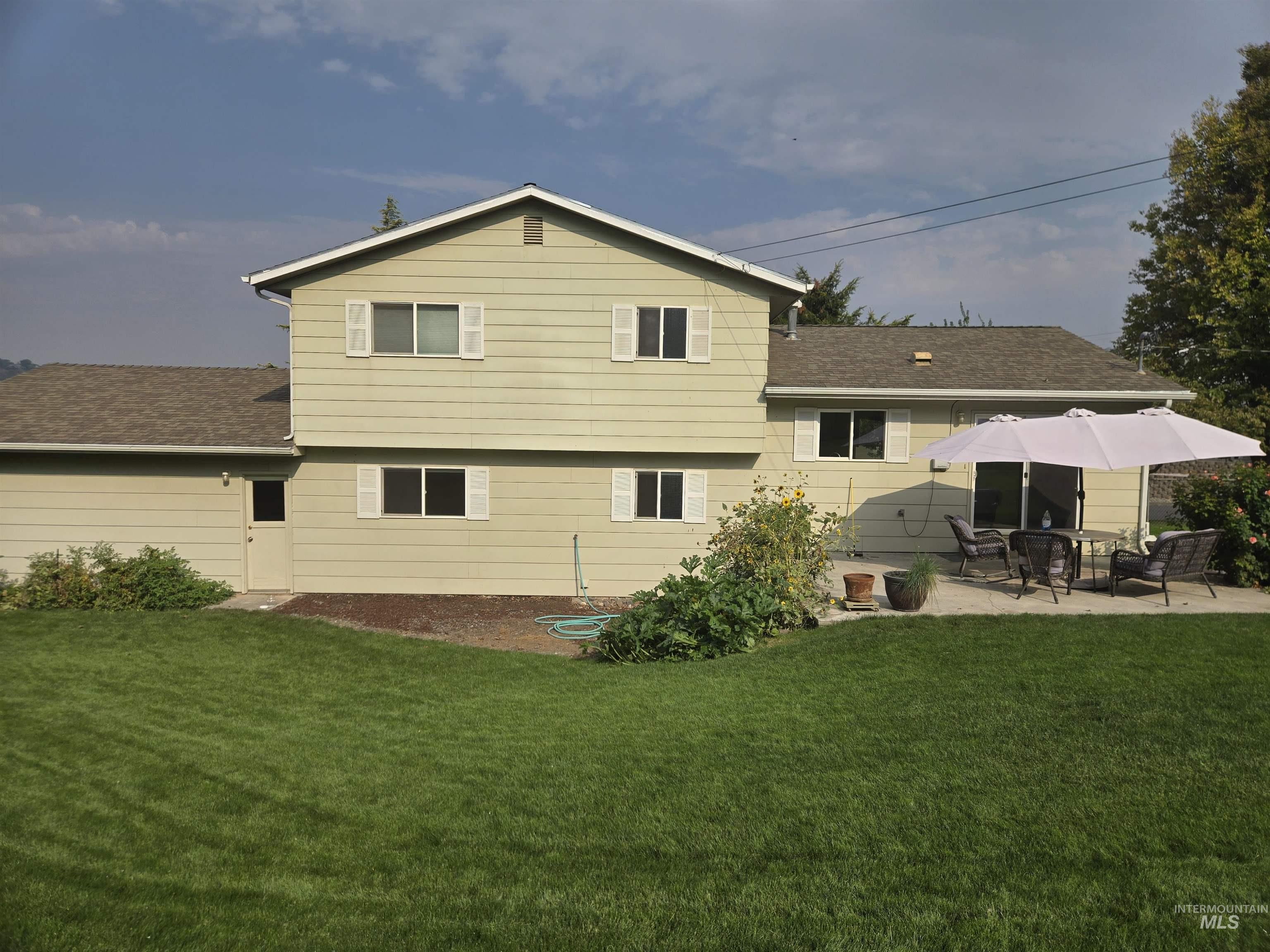 3403 Meadowlark Drive Lewiston, ID 83501 - Photo 20 of 25 Rear view of property with a yard, a shingled roof, and a patio