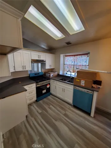 a kitchen with stainless steel appliances kitchen island granite countertop a sink counter space and cabinets