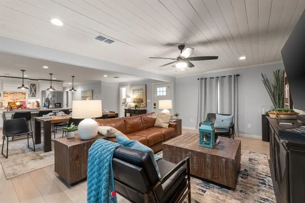 a living room with furniture a ceiling fan and a window