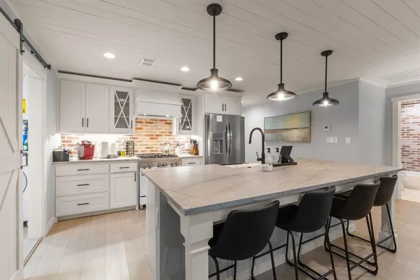 a kitchen with granite countertop a table chairs stainless steel appliances and cabinets