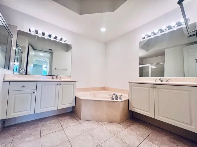 a spacious bathroom with a bathtub sink and mirror