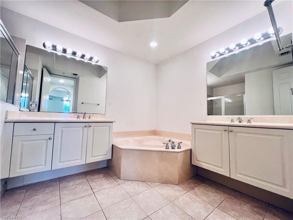 1435 Mariposa Circle, Unit 102 Naples, FL 34105 - Photo 11 of 24 a spacious bathroom with a large tub shower and sink