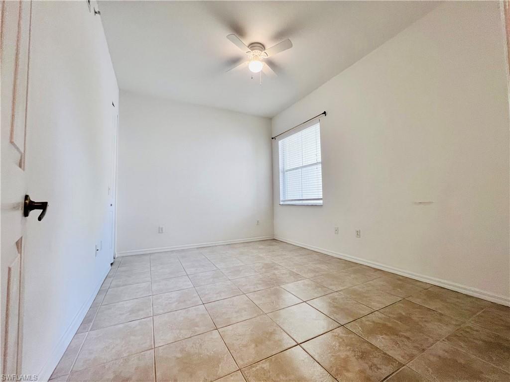 1435 Mariposa Circle, Unit 102 Naples, FL 34105 - Photo 13 of 24 an empty room with a ceiling fan and window