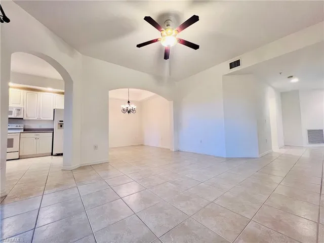 a view of a livingroom with a chandelier fan and windows