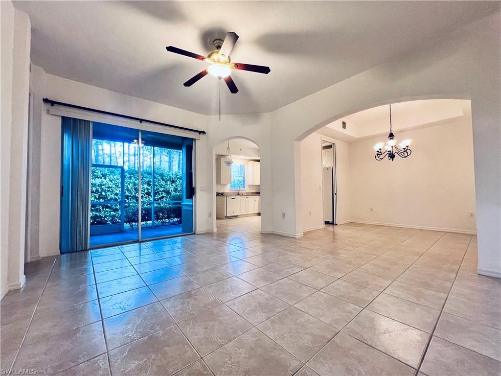 1435 Mariposa Circle, Unit 102 Naples, FL 34105 - Photo 4 of 24 a view of a livingroom with a chandelier fan and windows