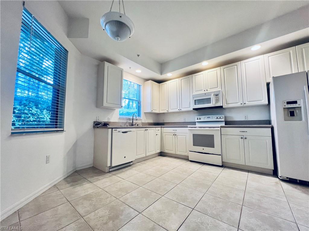 1435 Mariposa Circle, Unit 102 Naples, FL 34105 - Photo 6 of 24 a kitchen with cabinets and window
