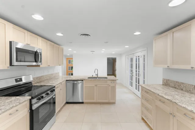 a kitchen with stainless steel appliances granite countertop a stove top oven a sink dishwasher and a refrigerator
