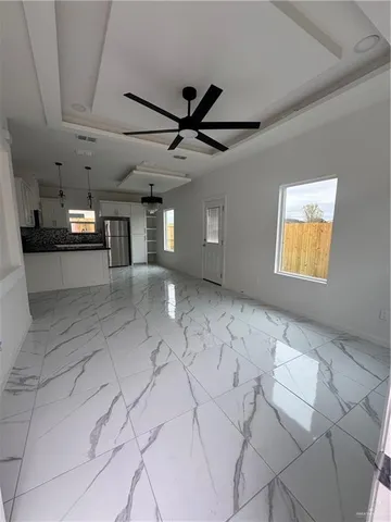 a view of a livingroom with a ceiling fan and window