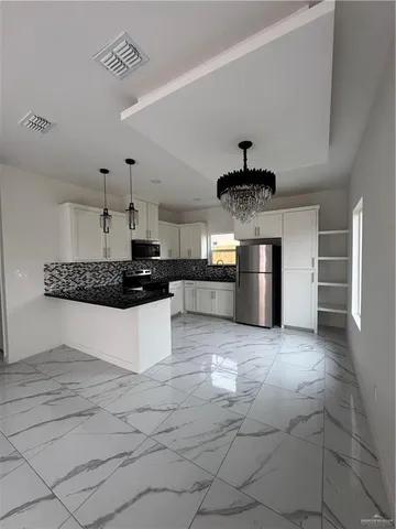 a large kitchen with stainless steel appliances granite countertop a stove a sink and a refrigerator