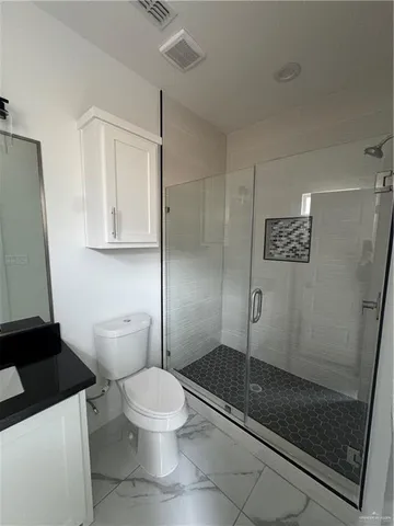 a bathroom with a toilet and a shower