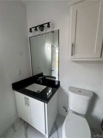 a bathroom with a sink a toilet and mirror