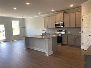 a kitchen with stainless steel appliances granite countertop a sink a stove a refrigerator and cabinets