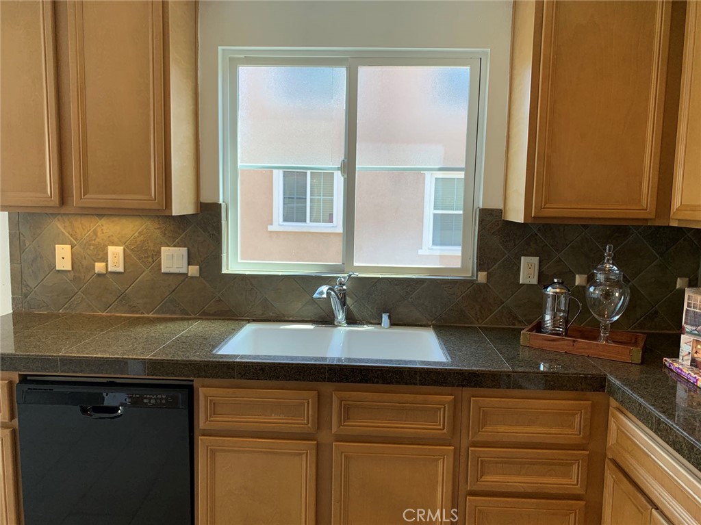 2813 Yacht Way Oxnard, CA 93035 - Photo 9 of 24 a kitchen with granite countertop a sink a window and cabinets