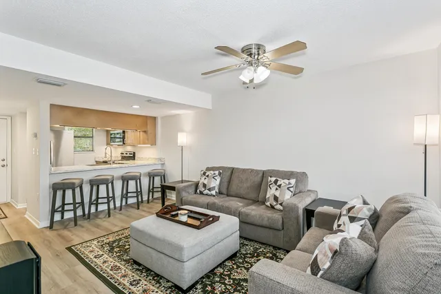 a living room with furniture and a wooden floor