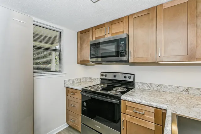 a kitchen with granite countertop cabinets stainless steel appliances and wooden floor