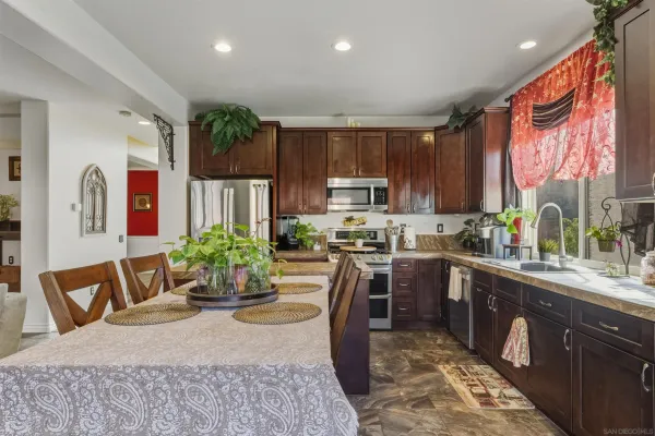 a kitchen with stainless steel appliances granite countertop sink stove top oven and cabinets