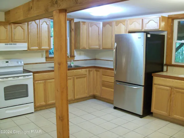 a kitchen with a refrigerator sink and cabinets