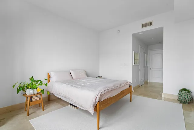 a bedroom with a bed and a potted plant