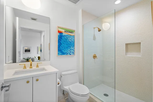 a bathroom with a sink a mirror a toilet and shower