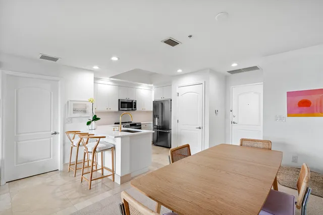 a kitchen with stainless steel appliances kitchen island granite countertop a refrigerator and a stove top oven