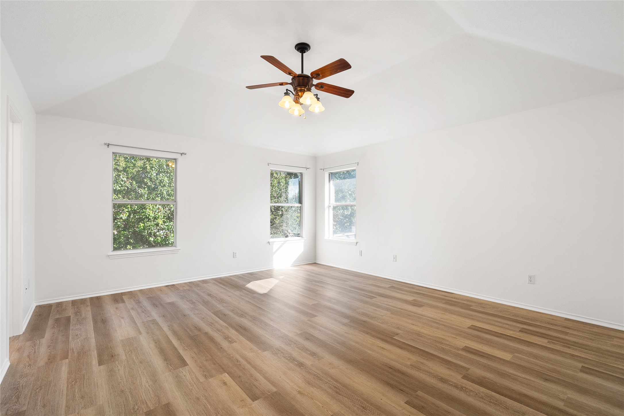 206 River Down Road Georgetown, TX 78628 - Photo 29 of 39 Spacious room featuring vaulted ceilings, wood-finish flooring, white walls, and a ceiling fan with integrated lighting