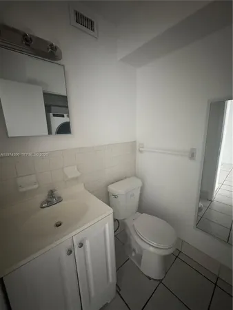 a white toilet sitting next to a bathroom sink