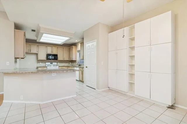 a kitchen with granite countertop white cabinets and stainless steel appliances