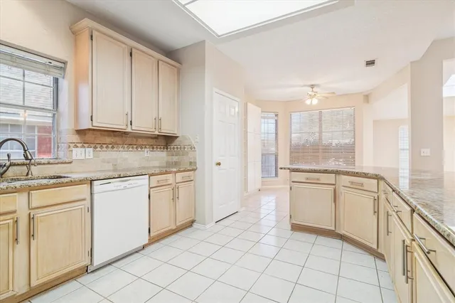 a kitchen with white cabinets appliances and a sink