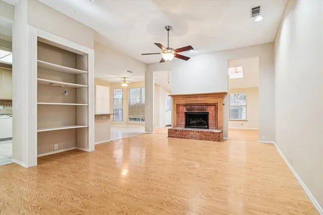 a view of an empty room with a fireplace and a window