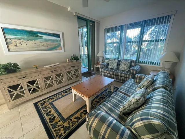 a living room with furniture and a floor to ceiling window