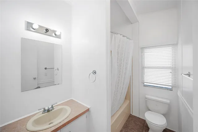 a bathroom with a granite countertop sink toilet a mirror and shower